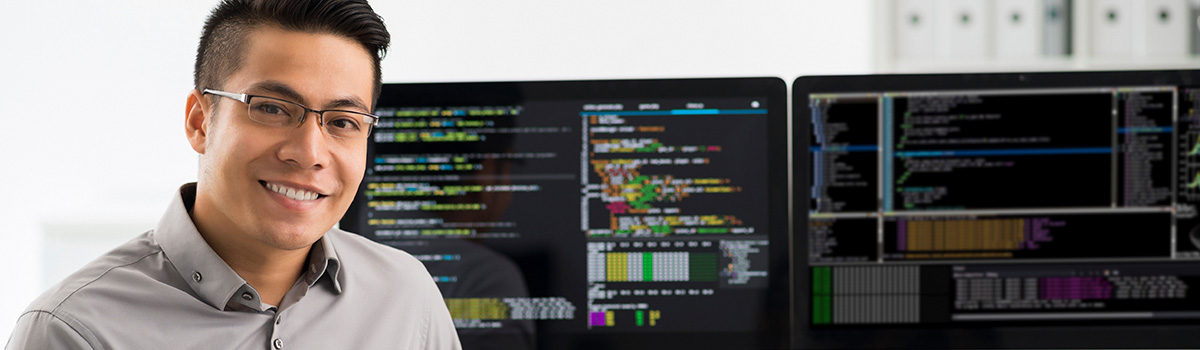 smiling young man with computer screens