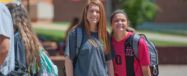 two smiling students outside