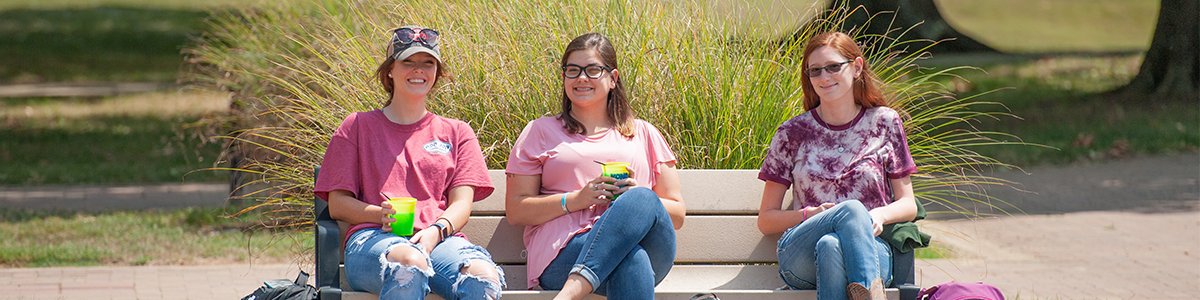 3 students sitting outside