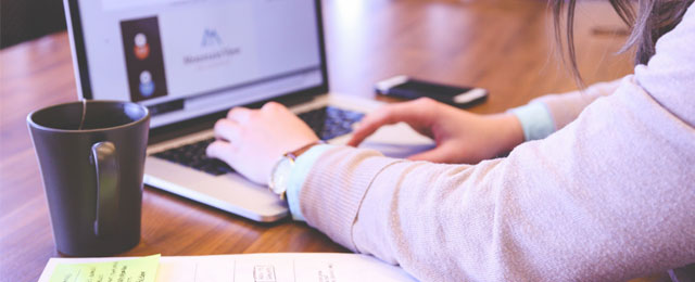 person's arms reaching for computer