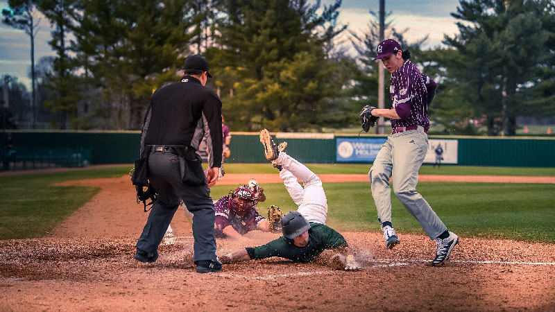 Baseball player sliding into home