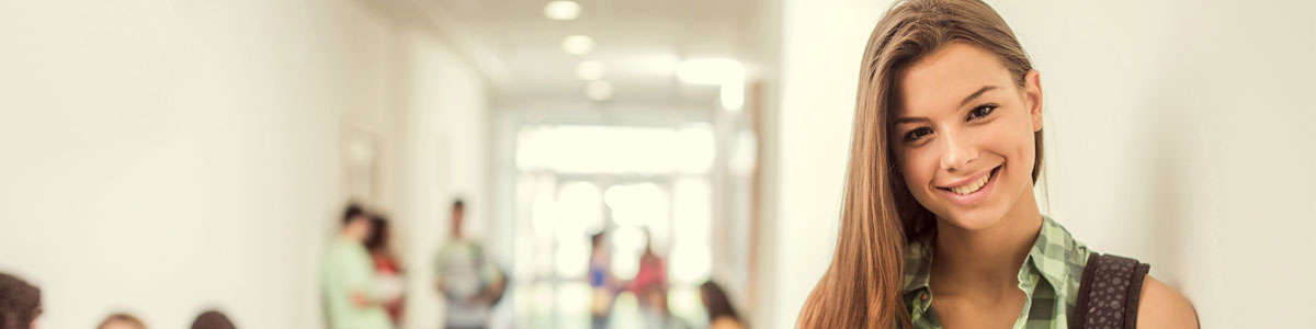 smiling student leaning against wall