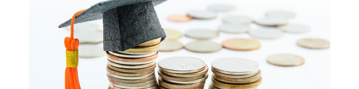 stacks of coins with graduation cap