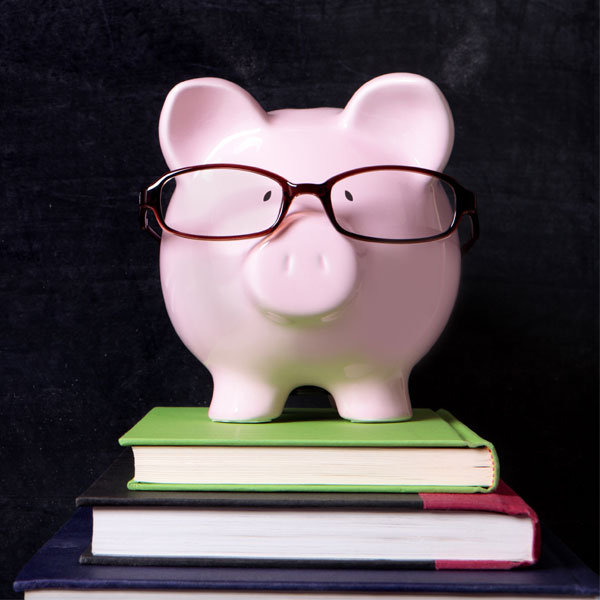 piggy bank with glasses sitting on books