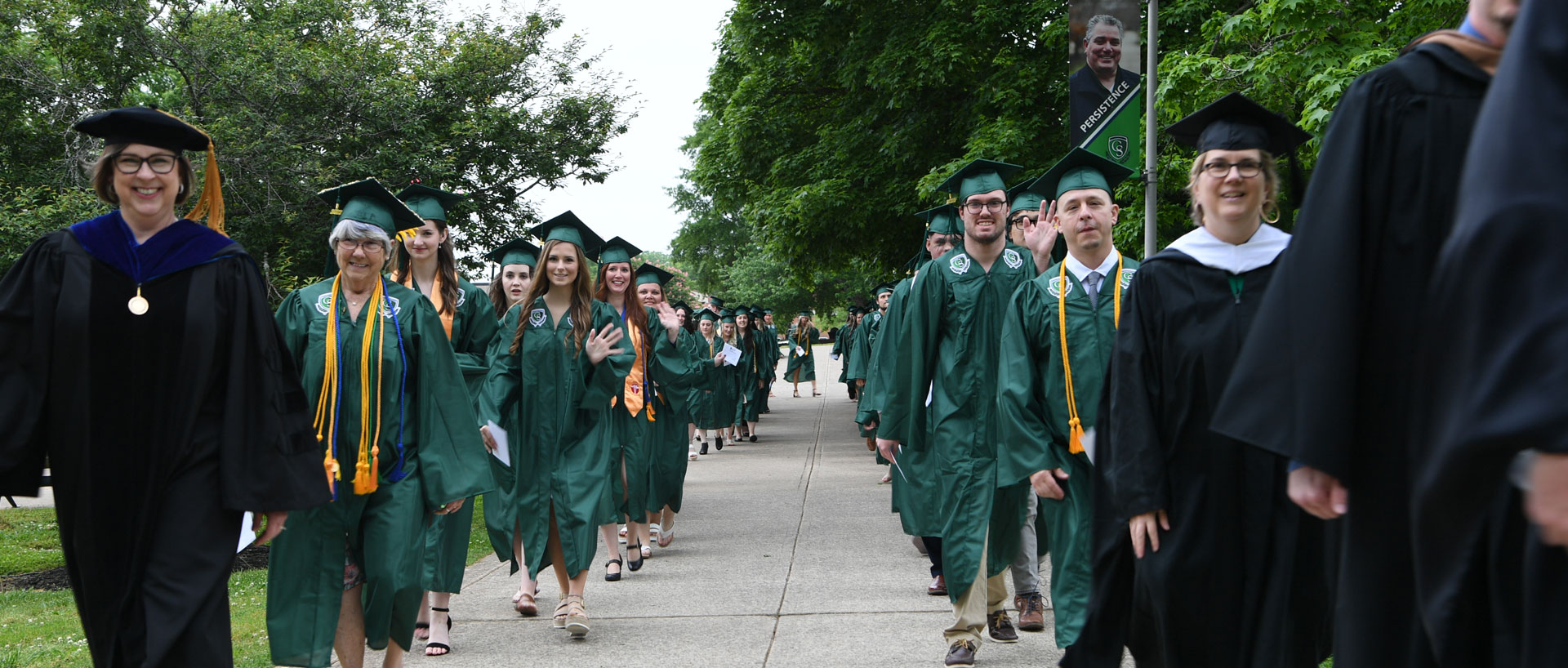 graduates walking across campus