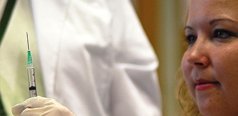 A woman checking a medical syringe