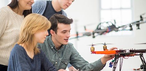 A group of four students testing a drone