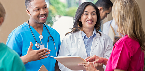 People in nursing and doctoral uniforms talking while smiling