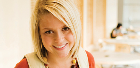 A woman with a backpack on smiling at the camera