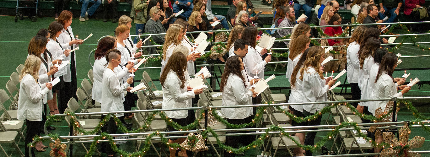 nursing grads with candles at pinning