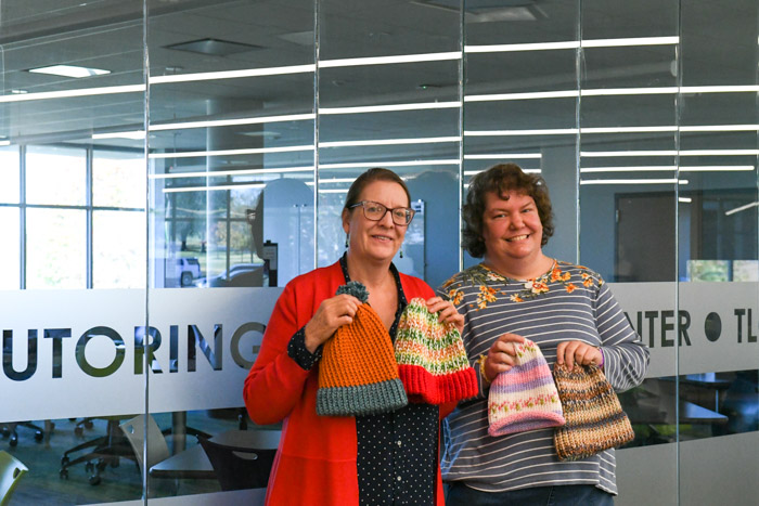 Anne Scott, Columbia State library director, and Sara Young, Columbia State library secretary with some of the student-made hats to be donated to Room in the Inn.