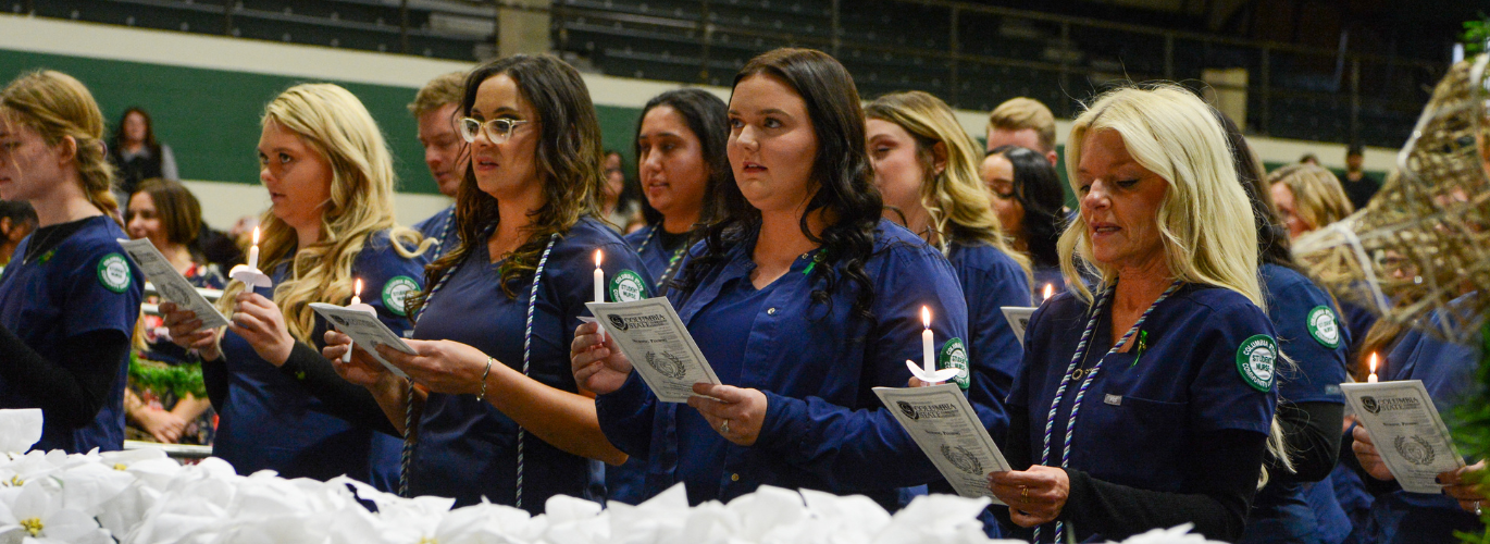 Students lighting candles during the Fall 24 Nursing Pinning Ceremony