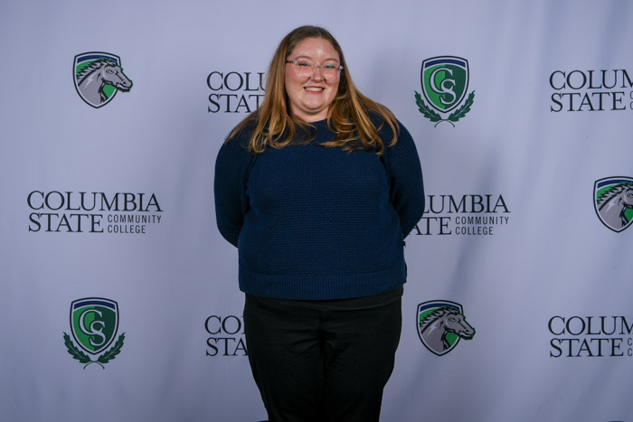 A person stands in front of a white background.
