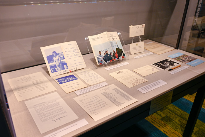 A glass display case features several written documents.