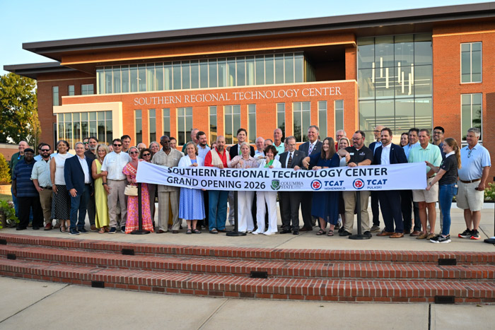 A large group of people hold a banner that says: "Southern Regional Technology Center Grand Opening 2026."