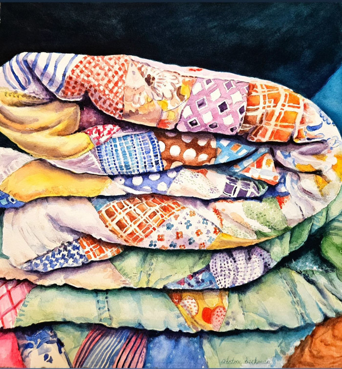 A watercolor painting shows colorfully patterned quilts folded in a pile.