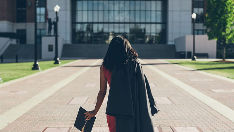 Recent graduate walking towards building