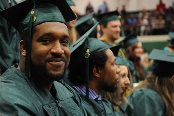 Male graduate sitting down