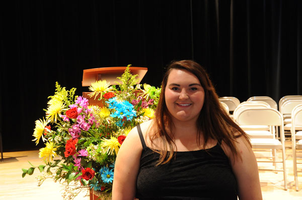 girl standing in front of flowers