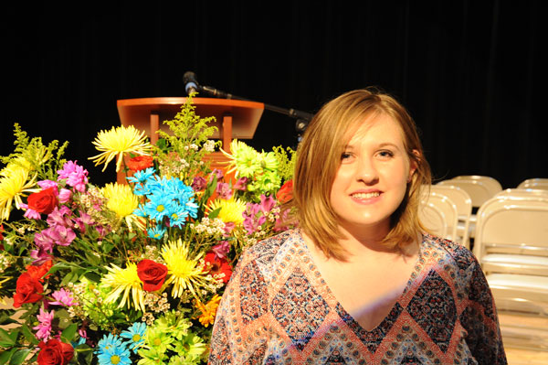 girl with red hair in front of flowers