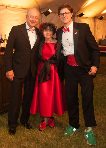 Two men in tuxes and woman in red dress