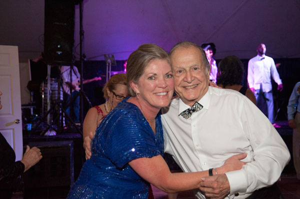 woman in blue dress hugging man