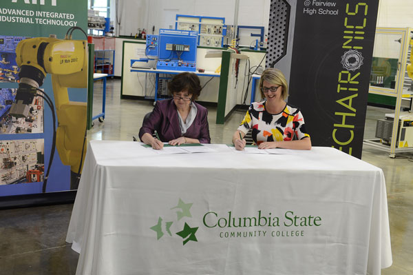 Two women signing papers