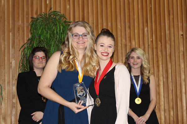 Two girls smiling with medals