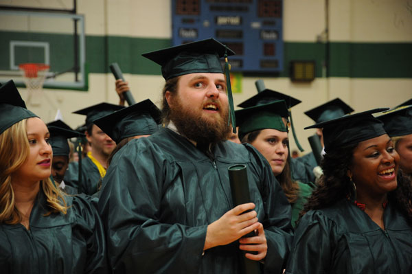 Male graduate between two girls