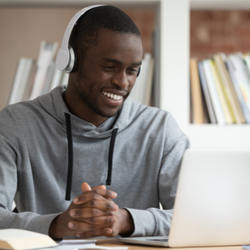 smiling male watching training course at laptop